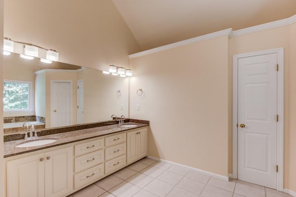 2405 Millwater Crossing Northeast Dacula, GA 30019 - Photo 39 of 63 a spacious bathroom with a granite countertop sink a mirror and a shower