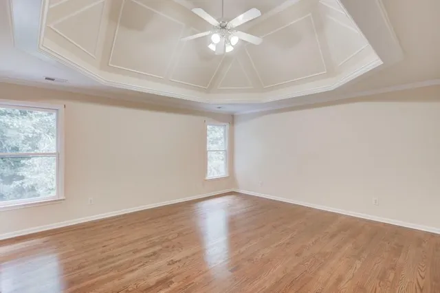 a view of a room with wooden floor chandelier and window