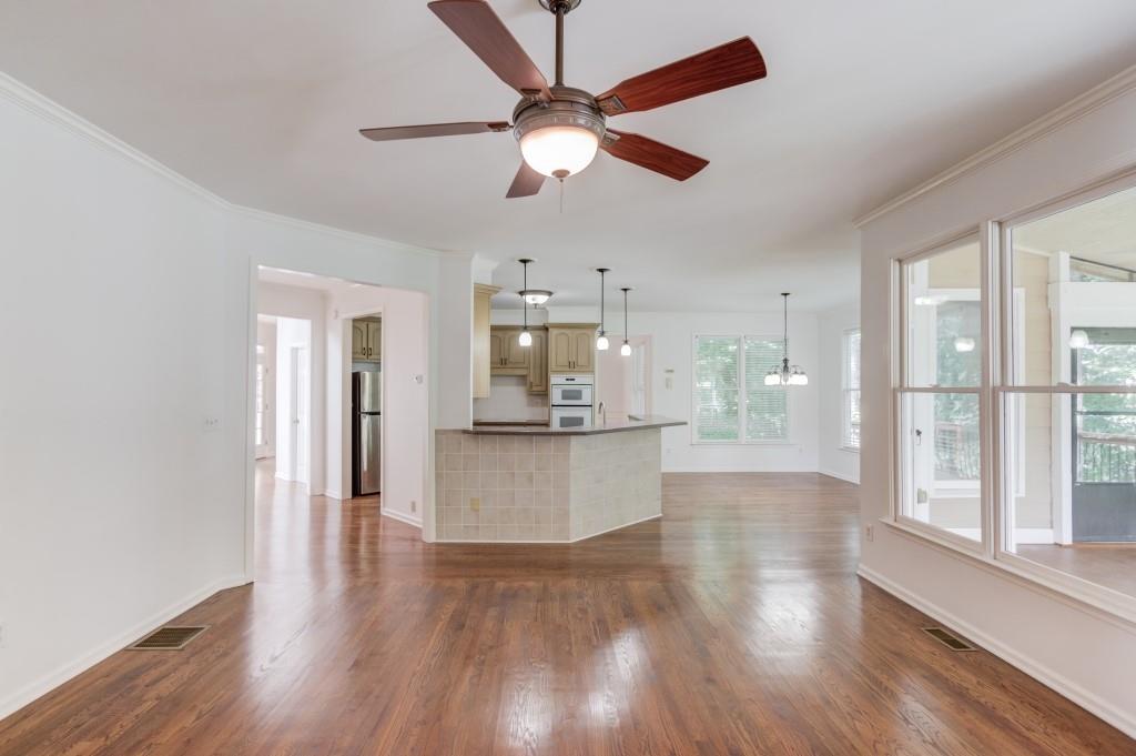 2405 Millwater Crossing Northeast Dacula, GA 30019 - Photo 51 of 63 a view of an empty room and kitchen with wooden floor
