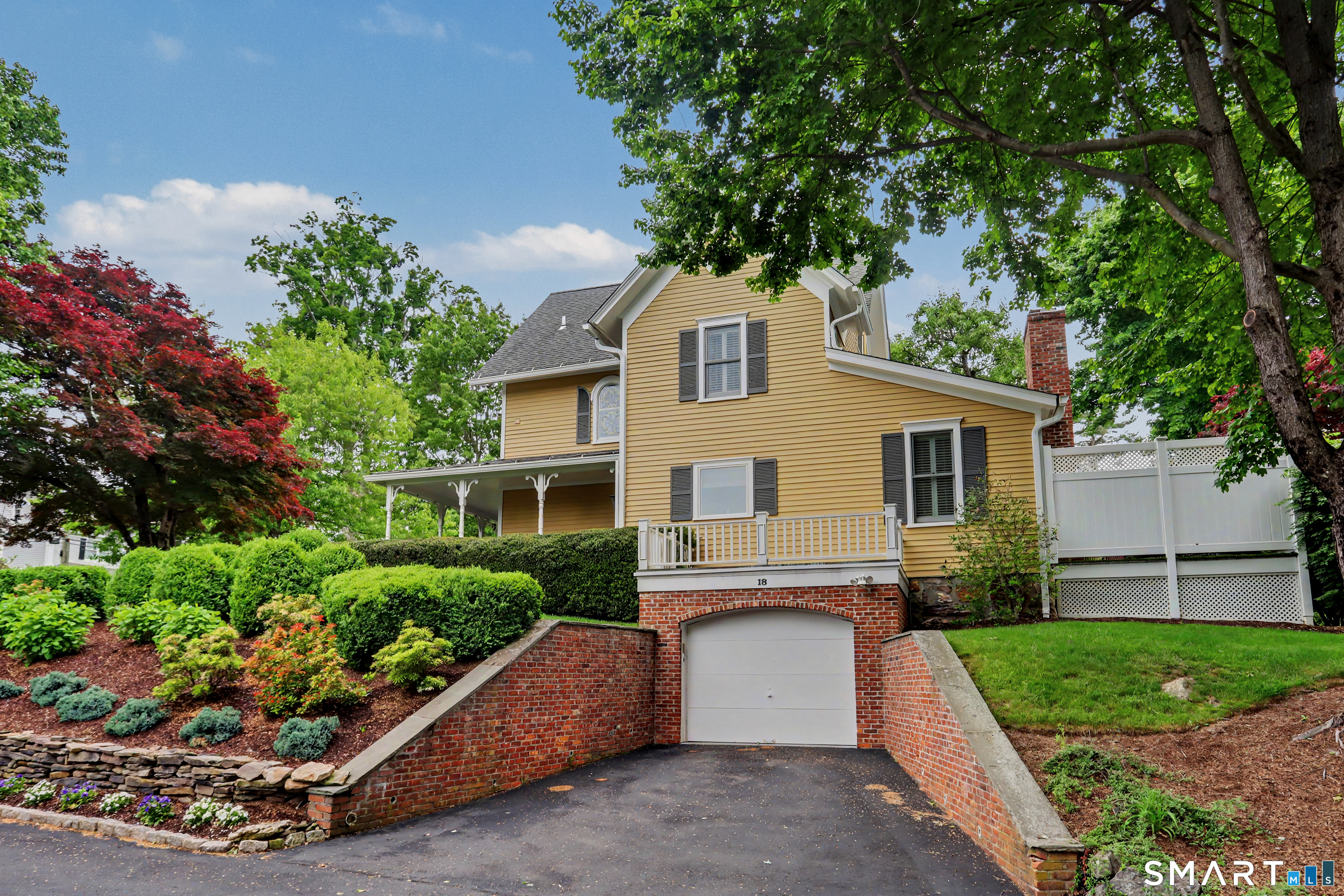 36 Catoonah Street, Unit 18 Ridgefield, CT 06877 - Photo 33 of 40 a front view of a house with a yard and a garage