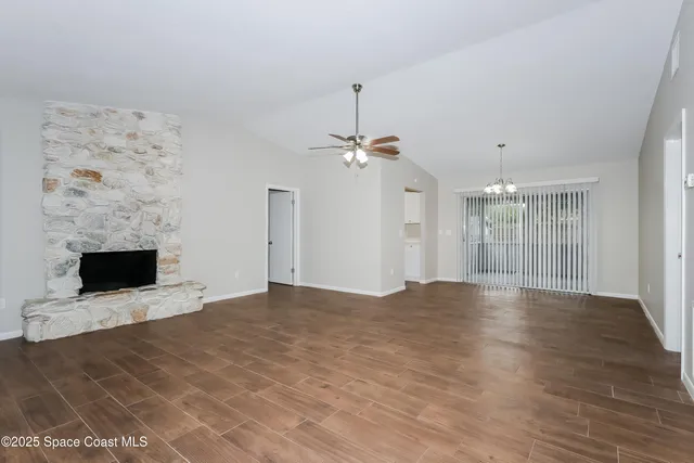 a view of an empty room with a fireplace and a window