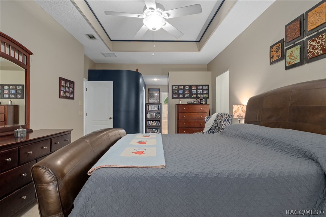 2460 West Pine Ridge Boulevard Beverly Hills, FL 34465 - Photo 23 of 47 a bedroom with a bed and dresser with mirror
