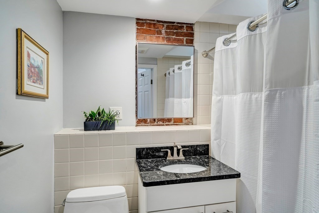 72 Rutland Street, Unit 3 Boston, MA 02118 - Photo 24 of 27 a bathroom with a granite countertop sink and a mirror
