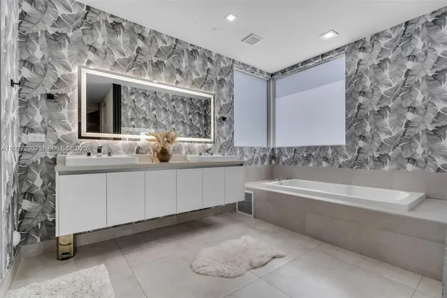 a bathroom with a double vanity sink mirror and bathtub