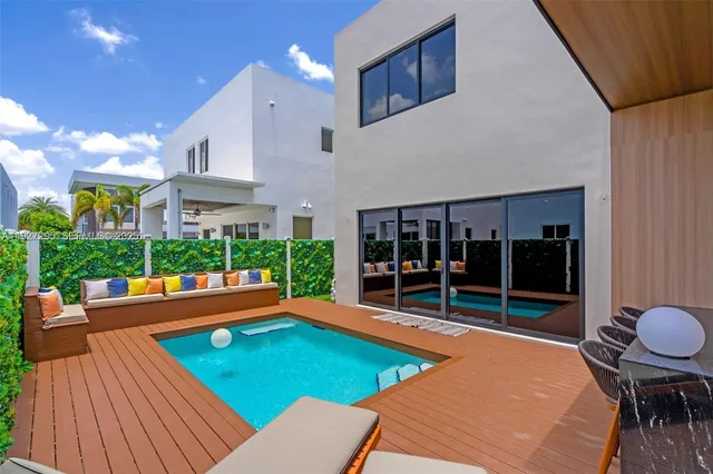 a view of a patio with table and chairs a barbeque with wooden floor and fence