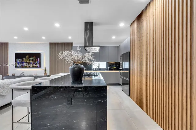 a kitchen with kitchen island stainless steel appliances a sink and cabinets