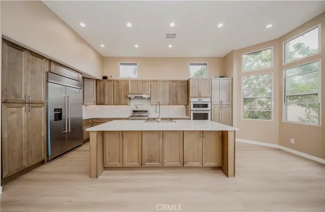 a kitchen with kitchen island a sink stove and refrigerator