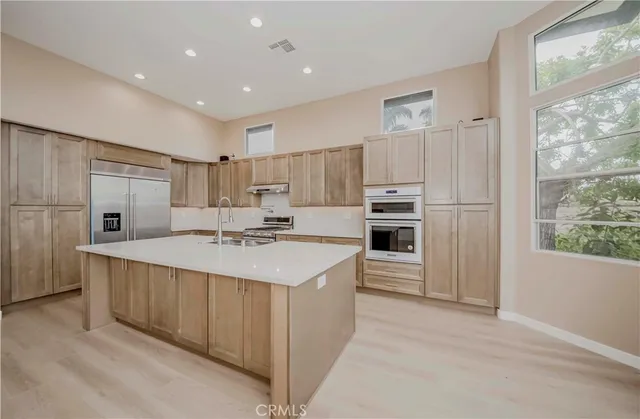 a kitchen with sink stove and refrigerator