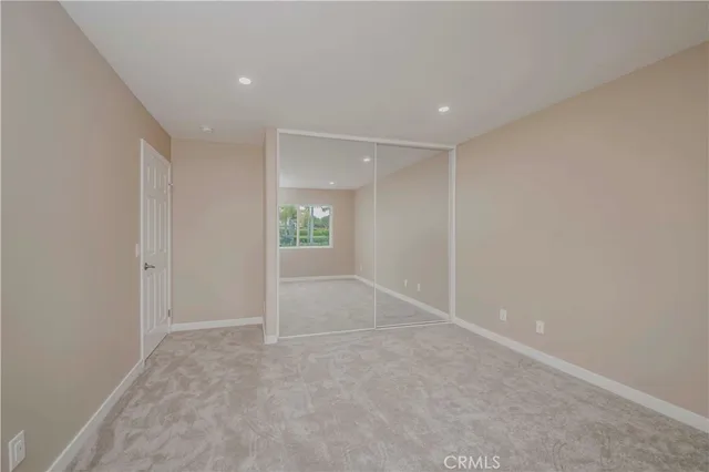 a bedroom with a large bed a potted plant and dresser