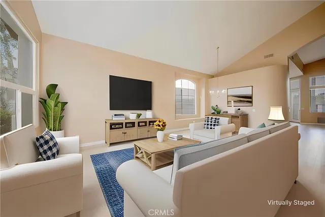 a living room with furniture a flat screen tv a rug and a window