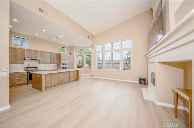 a large kitchen with stainless steel appliances kitchen island a large counter top and a wooden floors
