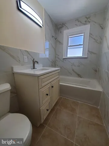 a bathroom with a granite countertop toilet sink and mirror