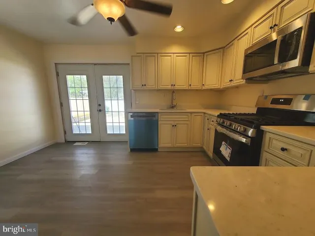 a kitchen with stainless steel appliances granite countertop a stove a sink and a microwave