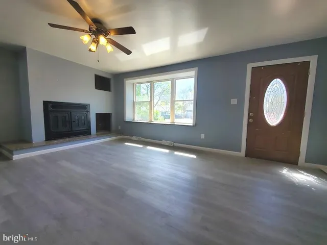 an empty room with windows fireplace and sink