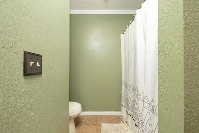 a bathroom with a toilet and a shower