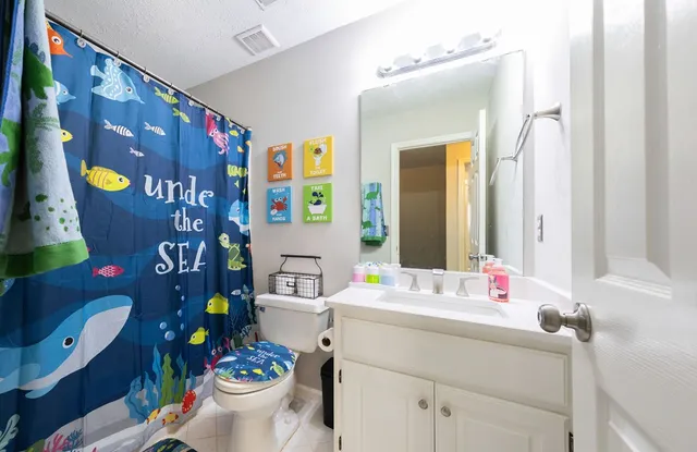 a bathroom with a sink mirror vanity and toilet