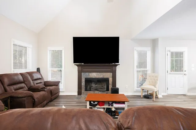 a living room with furniture a fireplace and a flat screen tv