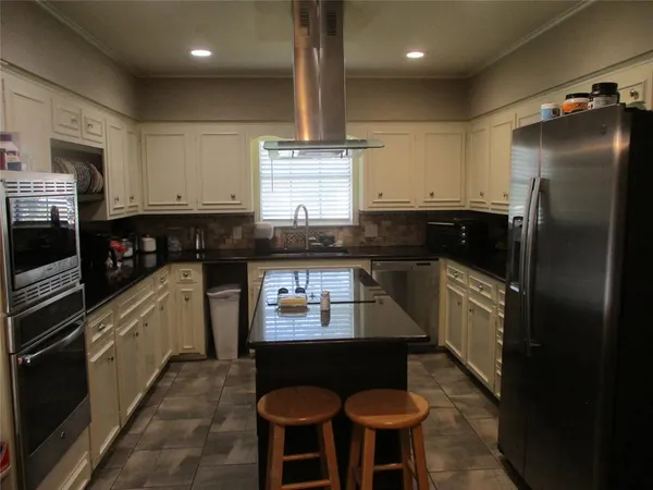 a kitchen with stainless steel appliances granite countertop a stove and a microwave