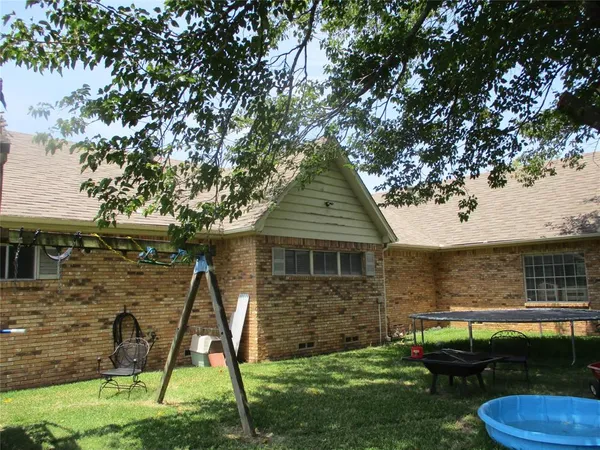a view of a backyard with plants and a tree