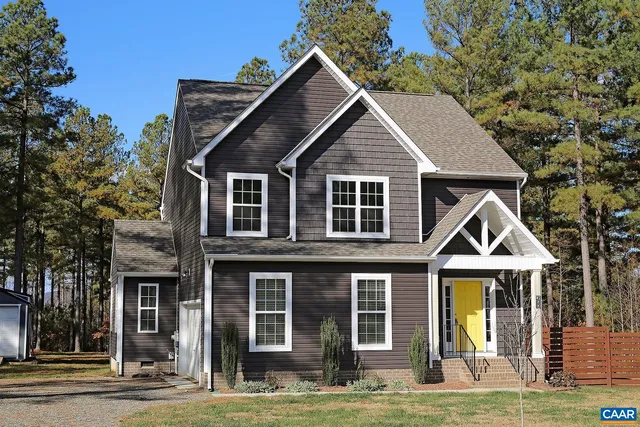 a view of a house with wooden walls and a small yard