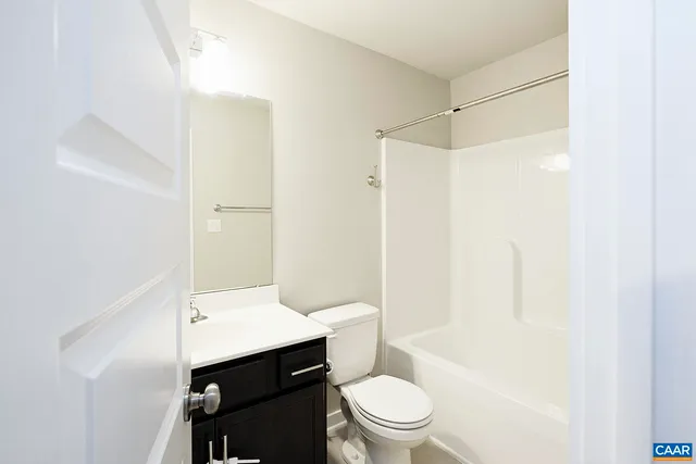 a bathroom with a sink a toilet a mirror and shower