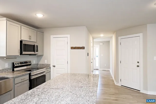 a kitchen with stainless steel appliances granite countertop a refrigerator and a stove top oven