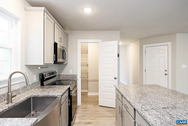 a kitchen with granite countertop a sink and stainless steel appliances