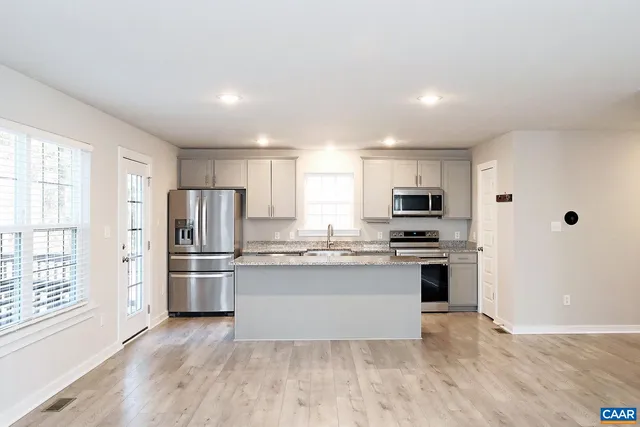 a kitchen with stainless steel appliances granite countertop a refrigerator and a stove top oven