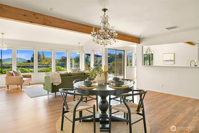 a view of a dining room with furniture large windows and wooden floor