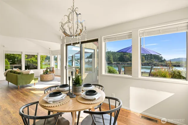 a dining room with furniture large windows and wooden floor