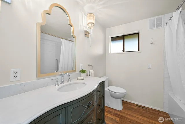 a bathroom with a sink a toilet and a mirror