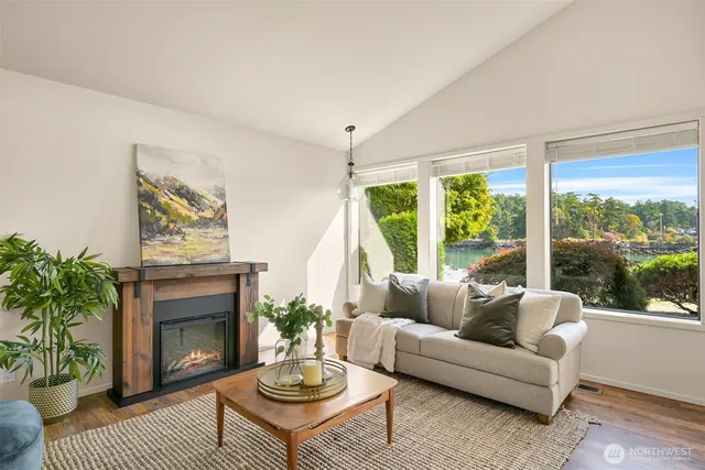 a living room with furniture a fireplace and a large window