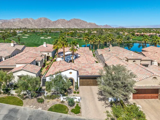 a view of a lake with couches and table and chairs under an umbrella