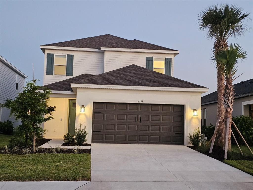 4233 Pond Brk Court Lakewood Ranch, FL 34211 - Photo 2 of 49 a front view of a house with a yard and garage