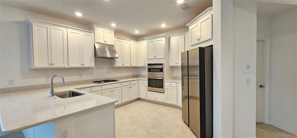 4233 Pond Brk Court Lakewood Ranch, FL 34211 - Photo 8 of 49 a kitchen with stainless steel appliances granite countertop a refrigerator and a sink