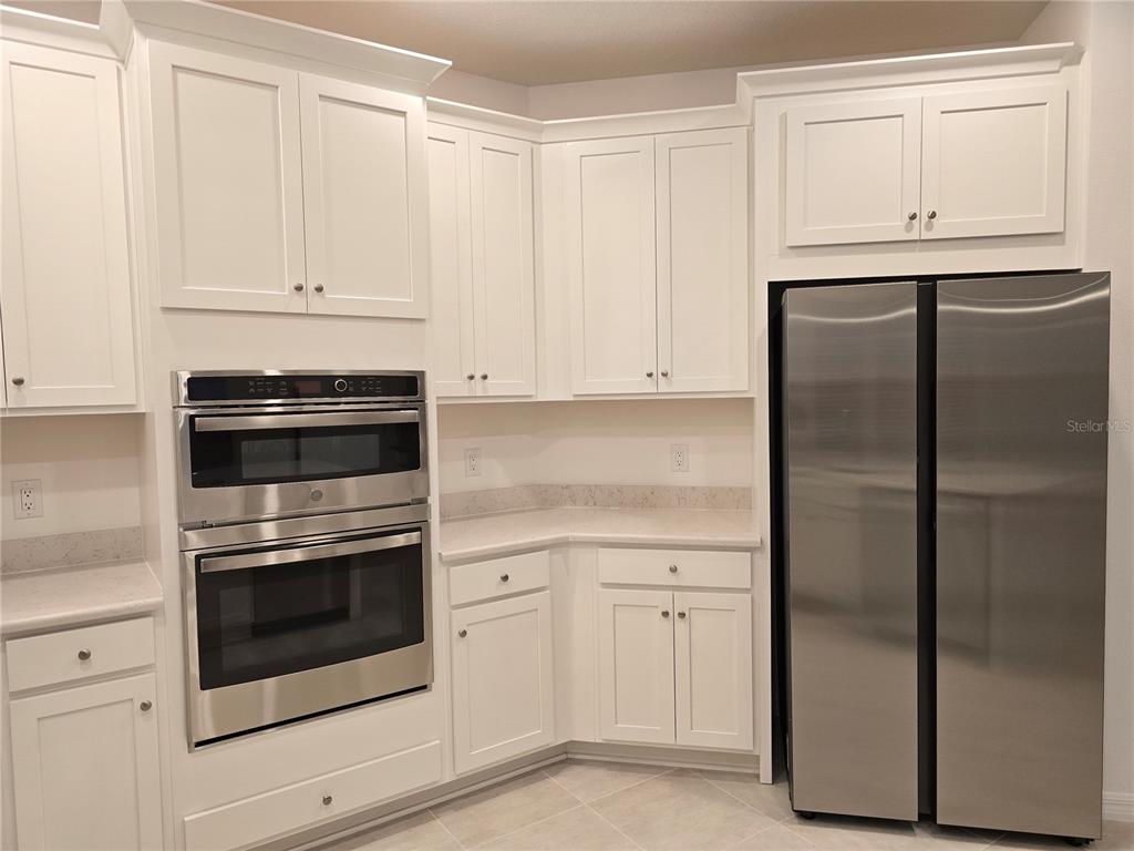 4233 Pond Brk Court Lakewood Ranch, FL 34211 - Photo 9 of 49 a kitchen with white cabinets and white appliances
