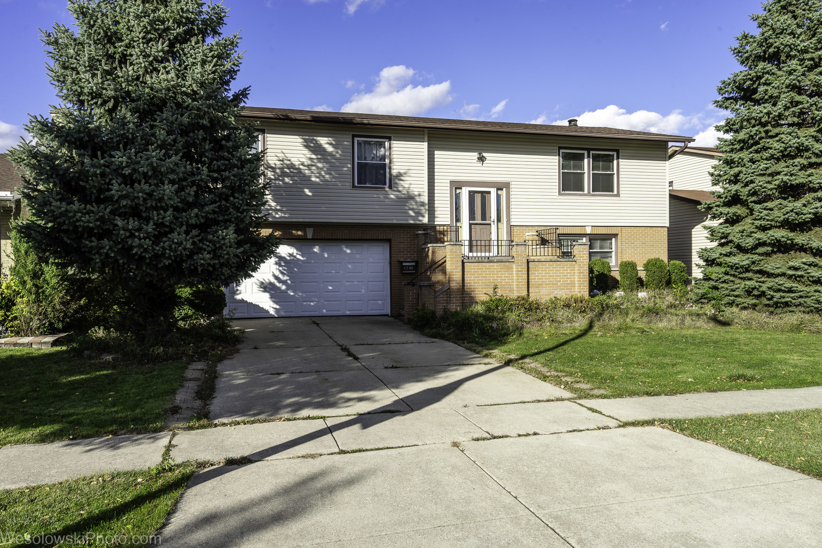 a front view of a house with a yard and a garage