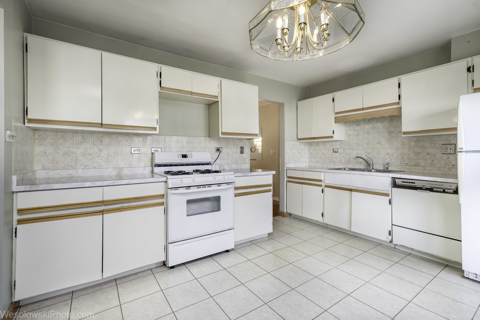 1822 West Catalpa Lane Mount Prospect, IL 60056 - Photo 3 of 24 a kitchen with granite countertop white cabinets and white appliances