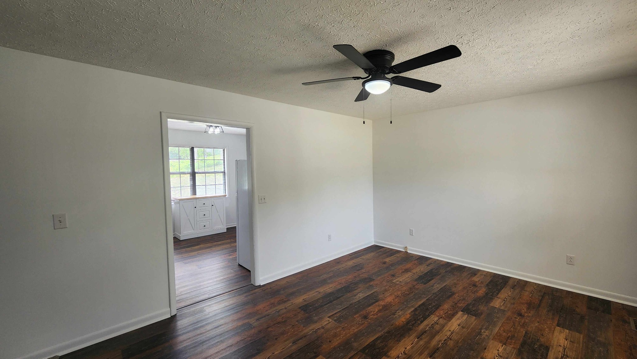 1825 Free Hill Road Celina, TN 38551 - Photo 5 of 49 an empty room with wooden floor a ceiling fan and windows