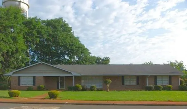 a front view of a house with a garden
