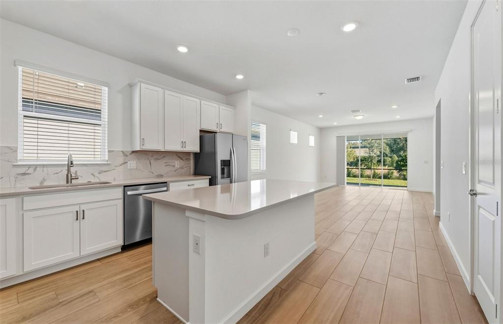 13764 Rocky Pne Place Spring Hill, FL 34610 - Photo 5 of 29 a kitchen with stainless steel appliances granite countertop a sink a stove a refrigerator and cabinets