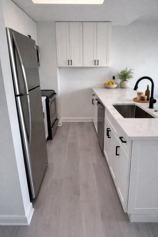 390 Commonwealth Avenue, Unit 809 Boston, MA 02215 - Photo 2 of 11 a kitchen with stainless steel appliances a refrigerator sink and white cabinets