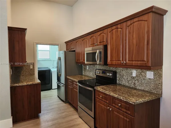 a kitchen with stainless steel appliances granite countertop a stove a sink and a microwave