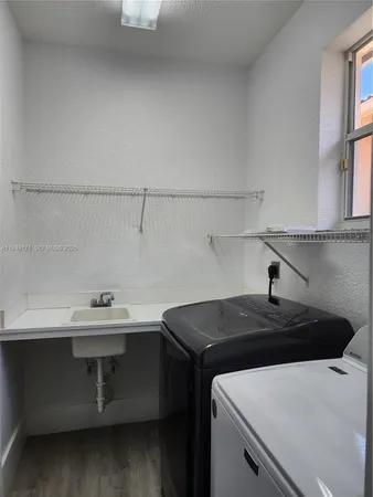 a utility room with a sink a vanity and window