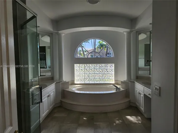 a view of spacious bathroom with a tub and window
