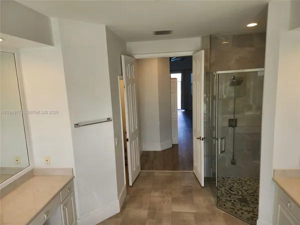 a bathroom with a sink and a glass door shower