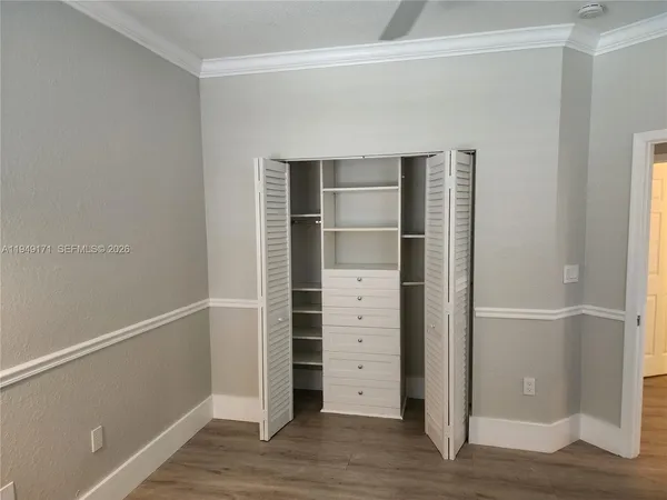 a view of walk in closet with empty racks