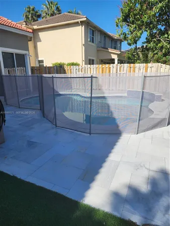 a view of a backyard with wooden floor and fence