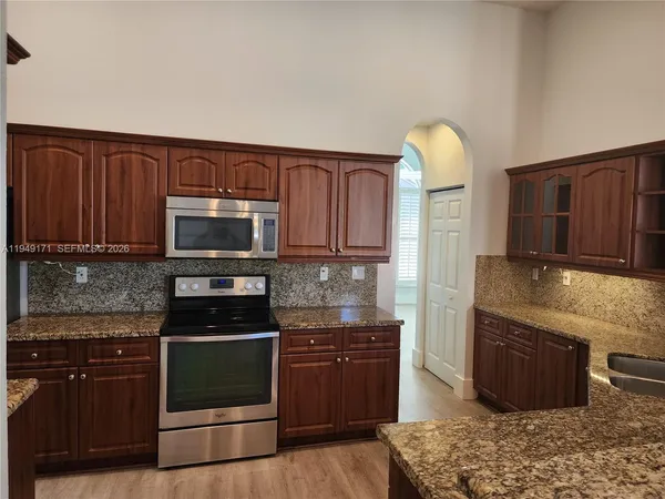 a kitchen with stainless steel appliances granite countertop a stove a sink and a microwave