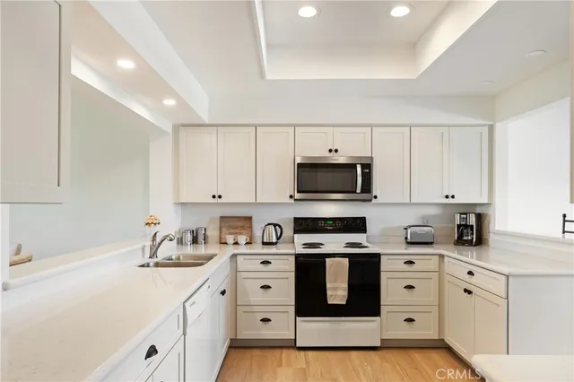 a kitchen with stainless steel appliances white cabinets and a sink